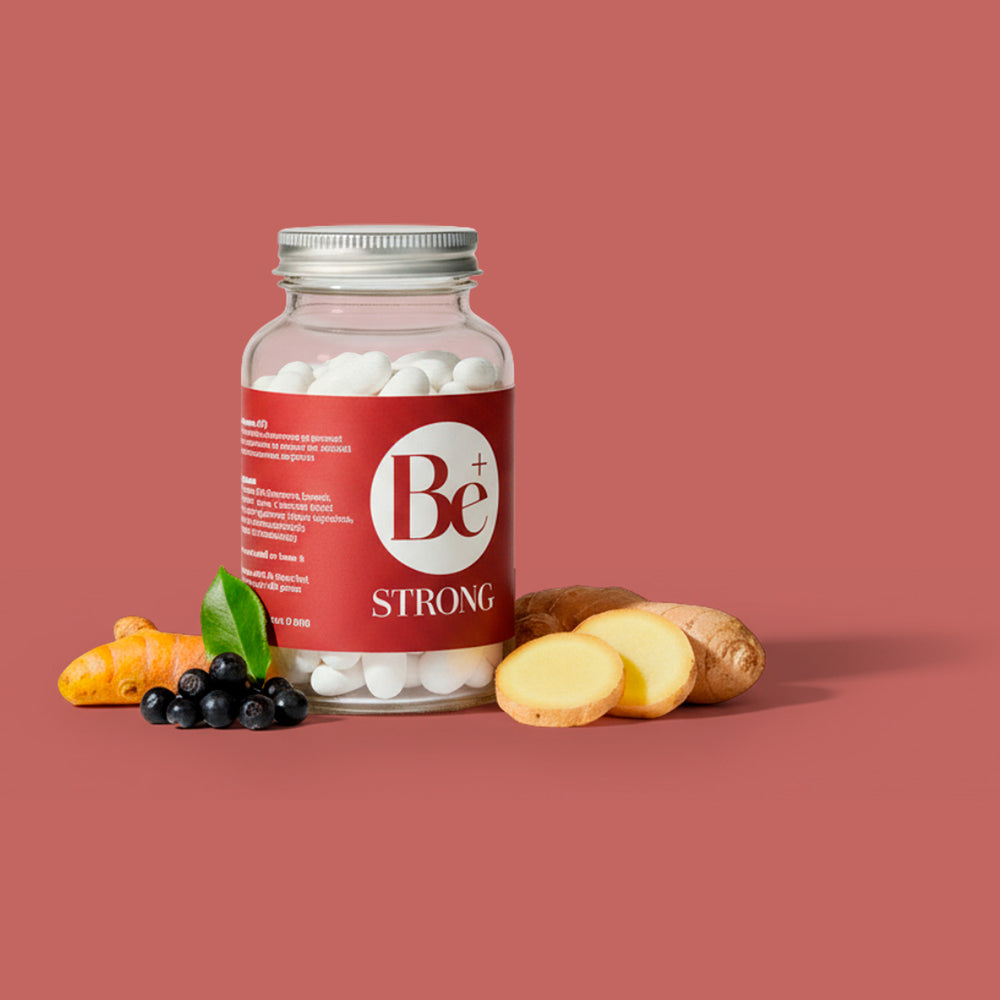 Be Strong supplement bottle with turmeric, berries, and ginger on a red background